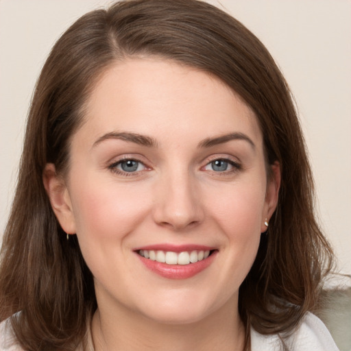 Joyful white young-adult female with long  brown hair and grey eyes