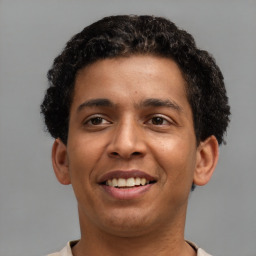 Joyful latino young-adult male with short  brown hair and brown eyes