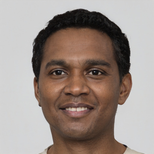 Joyful black young-adult male with short  black hair and brown eyes