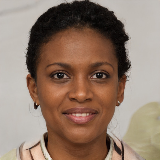 Joyful black young-adult female with short  brown hair and brown eyes