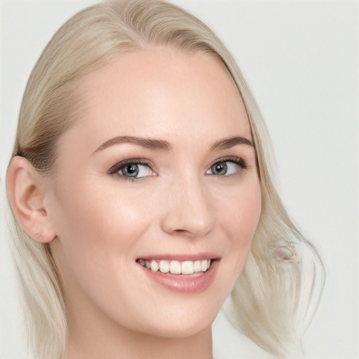 Joyful white young-adult female with long  blond hair and blue eyes