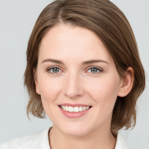 Joyful white young-adult female with medium  brown hair and grey eyes