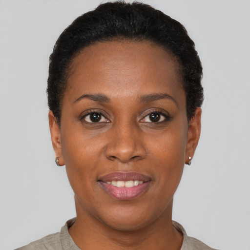 Joyful black young-adult female with short  black hair and brown eyes