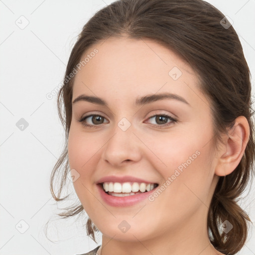 Joyful white young-adult female with medium  brown hair and green eyes