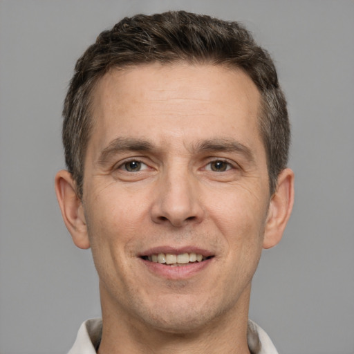 Joyful white adult male with short  brown hair and brown eyes