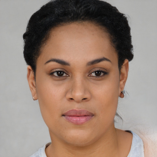 Joyful black young-adult female with short  black hair and brown eyes