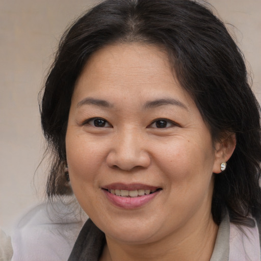 Joyful asian adult female with medium  brown hair and brown eyes