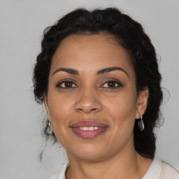 Joyful latino adult female with medium  brown hair and brown eyes