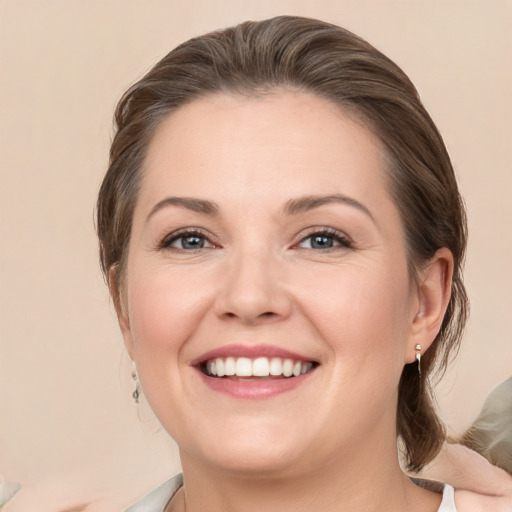 Joyful white young-adult female with medium  brown hair and grey eyes