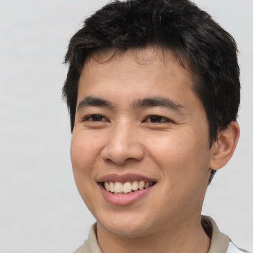 Joyful asian young-adult male with short  brown hair and brown eyes
