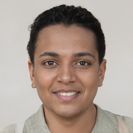Joyful black young-adult female with short  black hair and brown eyes