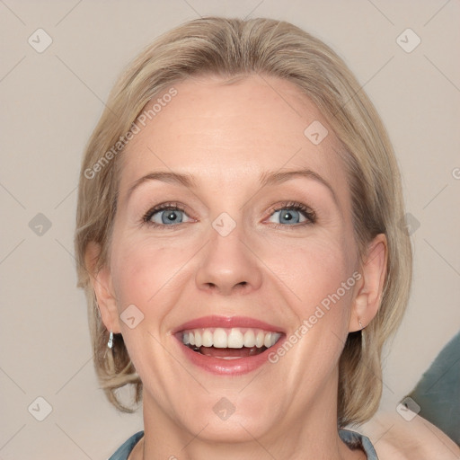 Joyful white adult female with medium  brown hair and blue eyes