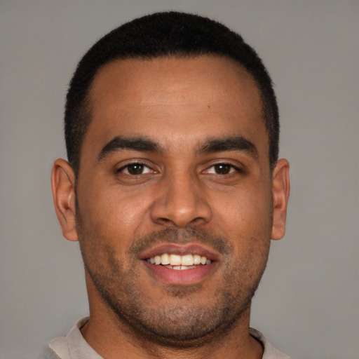 Joyful black young-adult male with short  black hair and brown eyes