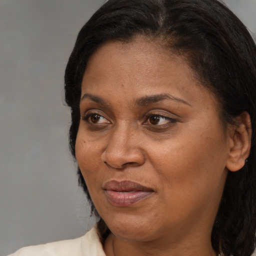 Joyful black adult female with medium  brown hair and brown eyes