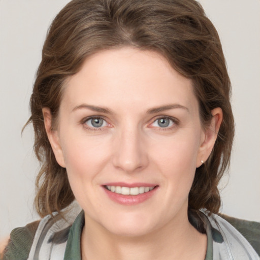 Joyful white young-adult female with medium  brown hair and grey eyes