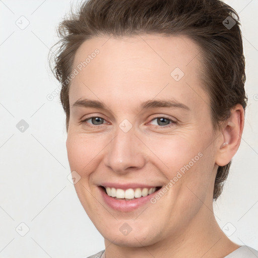 Joyful white young-adult female with short  brown hair and grey eyes