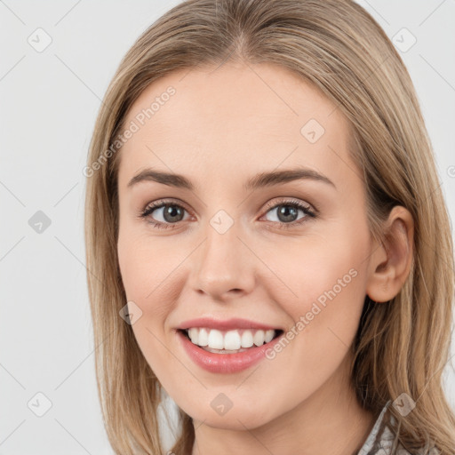 Joyful white young-adult female with long  brown hair and blue eyes