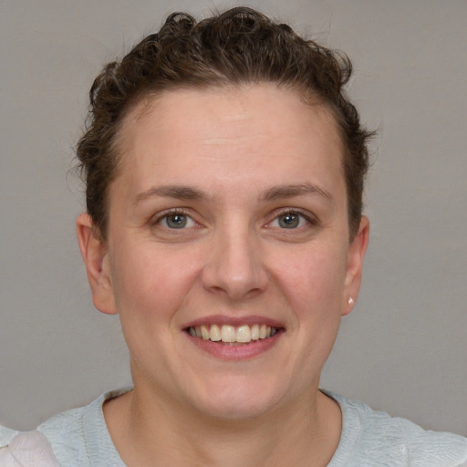 Joyful white young-adult female with short  brown hair and blue eyes