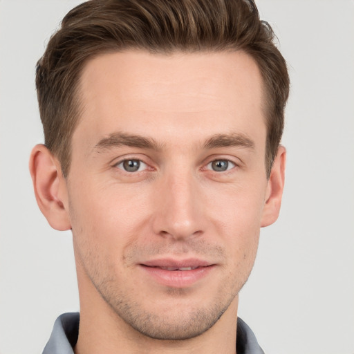 Joyful white young-adult male with short  brown hair and grey eyes