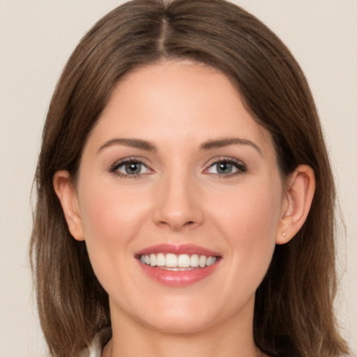 Joyful white young-adult female with long  brown hair and green eyes