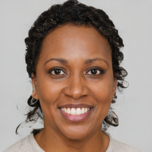 Joyful black adult female with short  brown hair and brown eyes