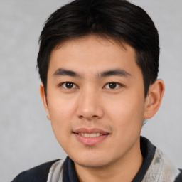 Joyful asian young-adult male with short  brown hair and brown eyes