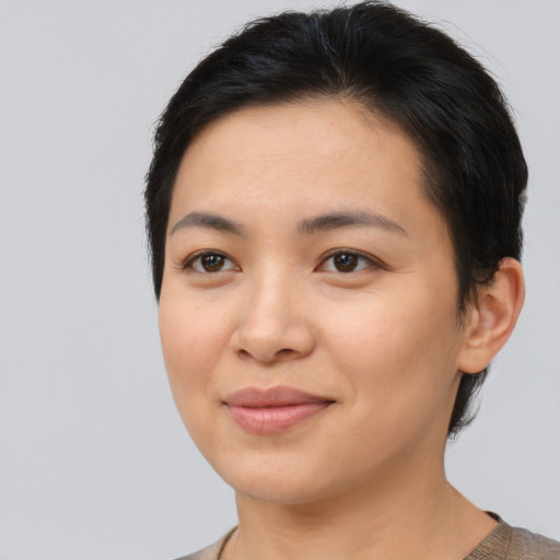Joyful asian young-adult female with short  brown hair and brown eyes