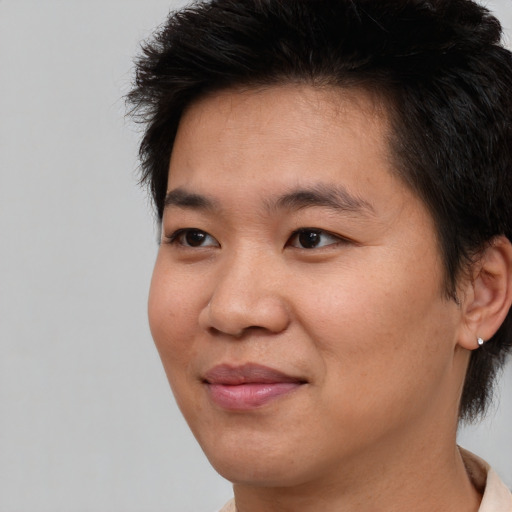 Joyful asian young-adult male with short  brown hair and brown eyes