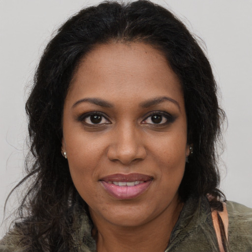 Joyful black young-adult female with long  brown hair and brown eyes