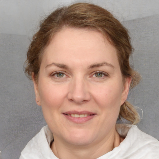 Joyful white adult female with medium  brown hair and grey eyes