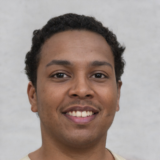 Joyful black young-adult male with short  brown hair and brown eyes