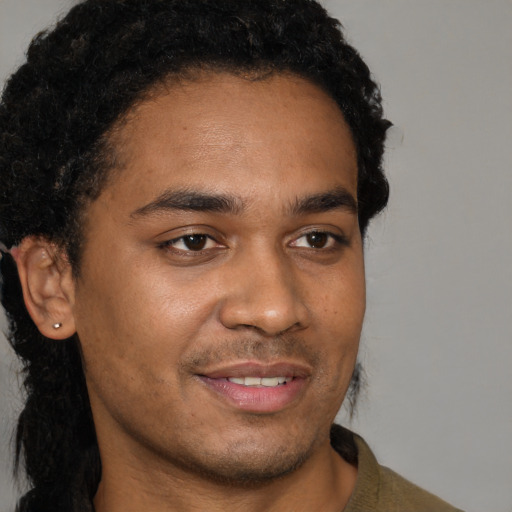 Joyful black young-adult male with short  brown hair and brown eyes