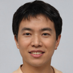 Joyful asian young-adult male with short  brown hair and brown eyes