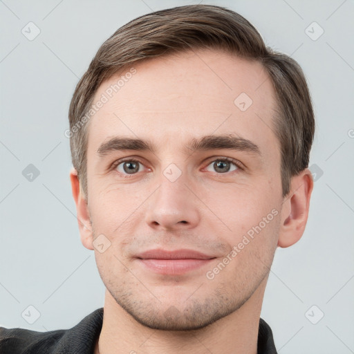 Joyful white young-adult male with short  brown hair and grey eyes