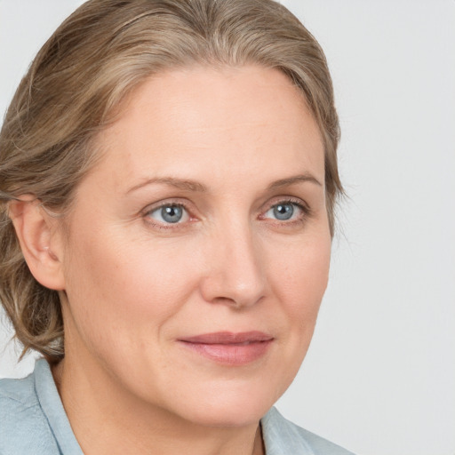 Joyful white adult female with medium  brown hair and blue eyes