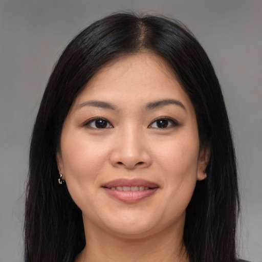 Joyful asian young-adult female with long  brown hair and brown eyes