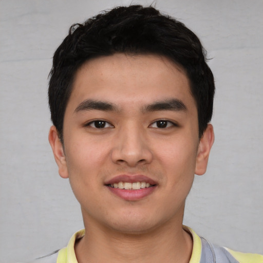 Joyful asian young-adult male with short  black hair and brown eyes