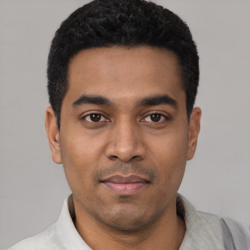 Joyful latino young-adult male with short  black hair and brown eyes