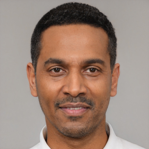 Joyful latino adult male with short  black hair and brown eyes