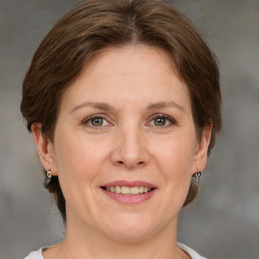 Joyful white adult female with medium  brown hair and grey eyes