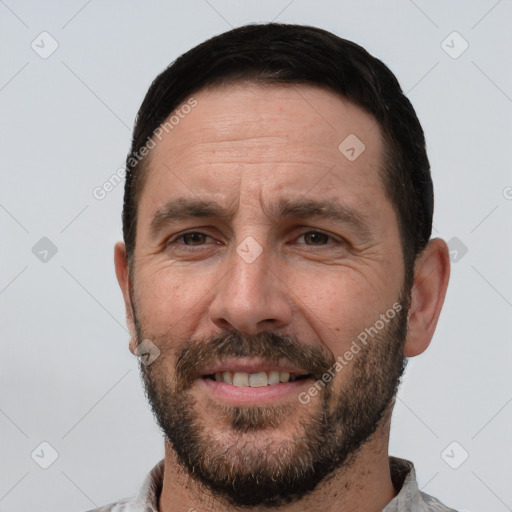 Joyful white adult male with short  black hair and brown eyes