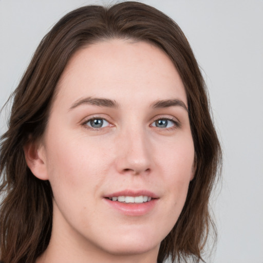 Joyful white young-adult female with long  brown hair and grey eyes