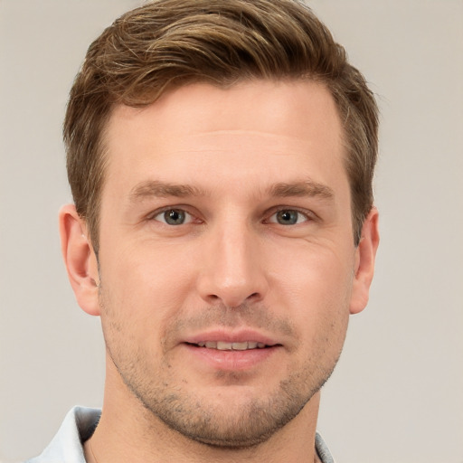 Joyful white young-adult male with short  brown hair and grey eyes