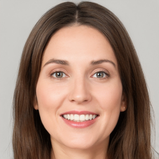 Joyful white young-adult female with long  brown hair and grey eyes