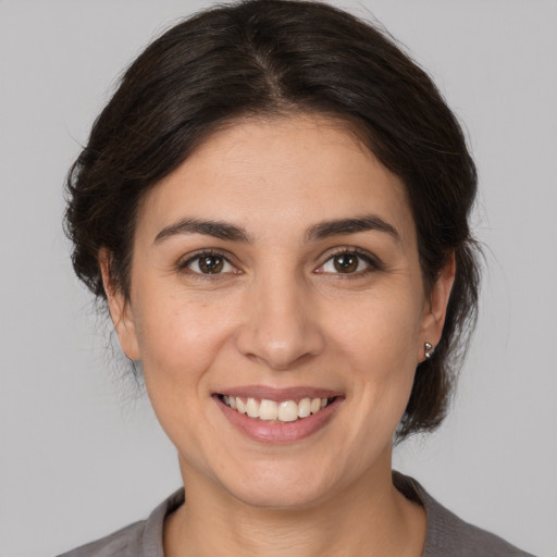 Joyful white young-adult female with medium  brown hair and brown eyes