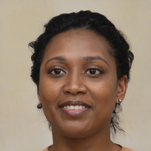 Joyful black young-adult female with short  black hair and brown eyes