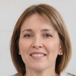 Joyful white adult female with medium  brown hair and grey eyes