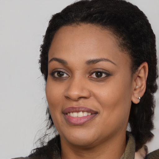 Joyful black young-adult female with medium  black hair and brown eyes