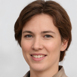 Joyful white young-adult female with medium  brown hair and grey eyes