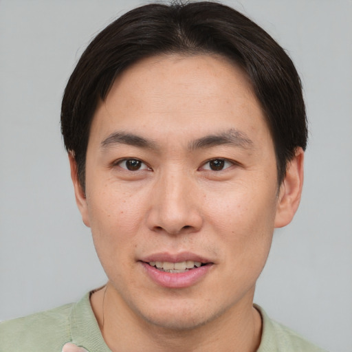 Joyful asian young-adult male with short  brown hair and brown eyes